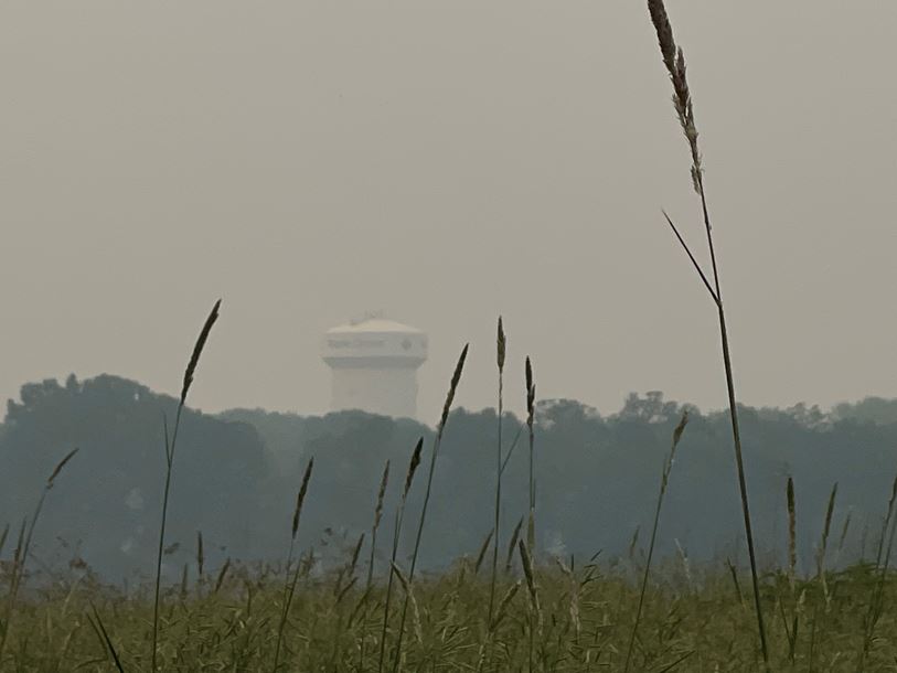 Hazy photo over field looking at the Maple Grove water tower on June 14, 2023 due to poor air quality.